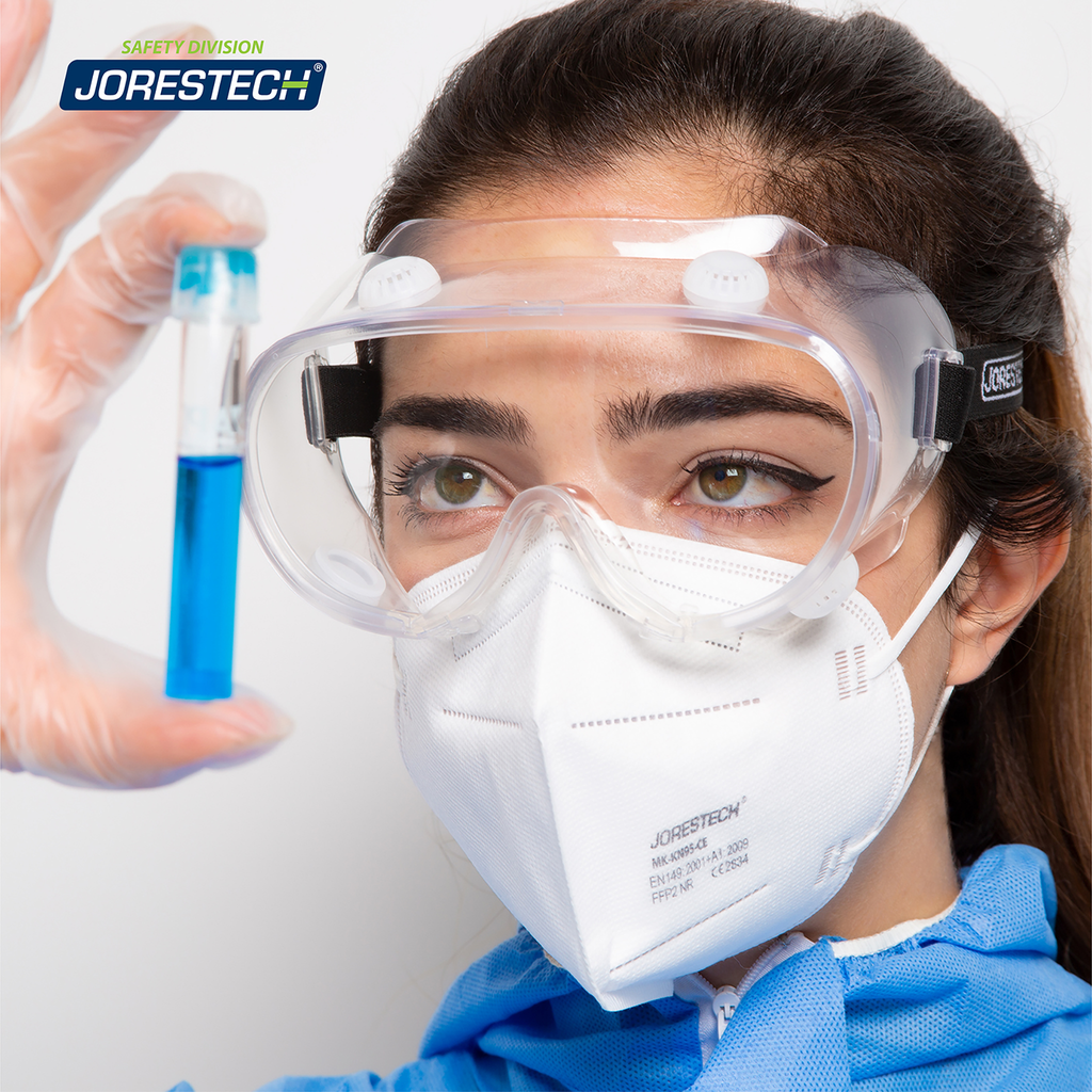 Image show a woman wearing the Anti fog ventilated safety goggles and disposable clothing in a setting of a laboratory