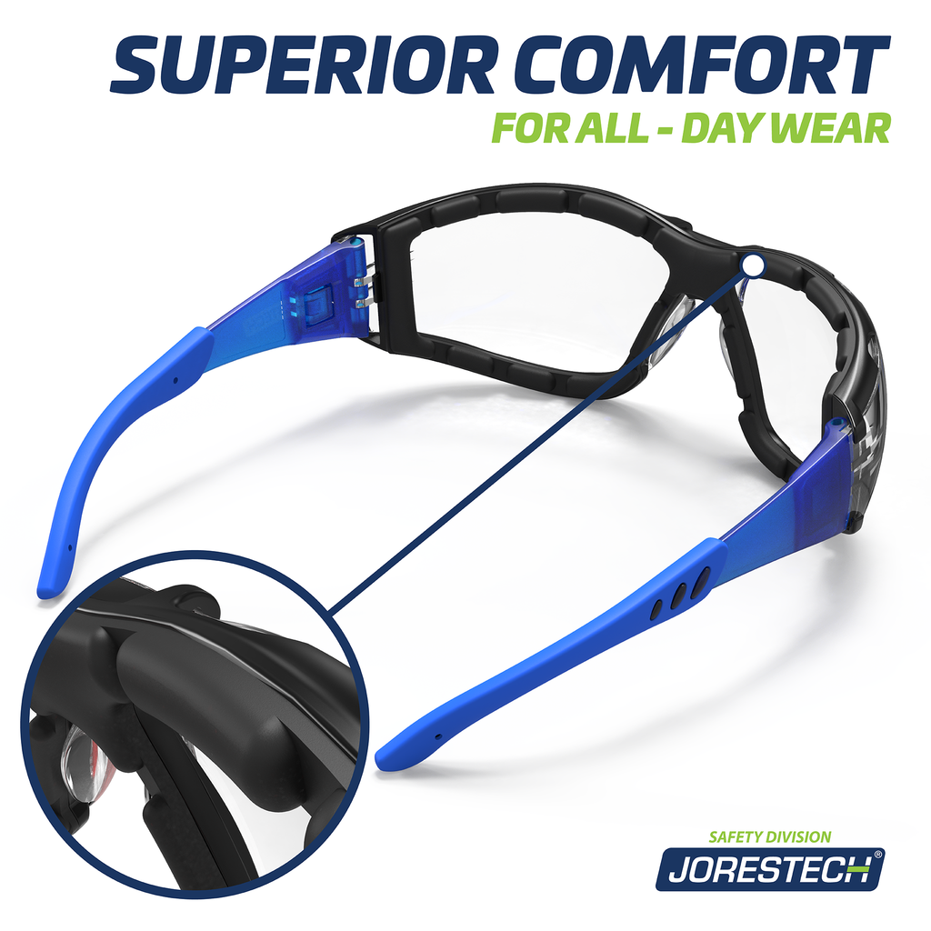 Image shows a view of the back of the blue and clear JORESTECH anti fog safety glasses convertibles to goggles with removable temples and elastic headband. Close up of the foam gasket is shown in a circle and text reads superior comfort for all day wear.