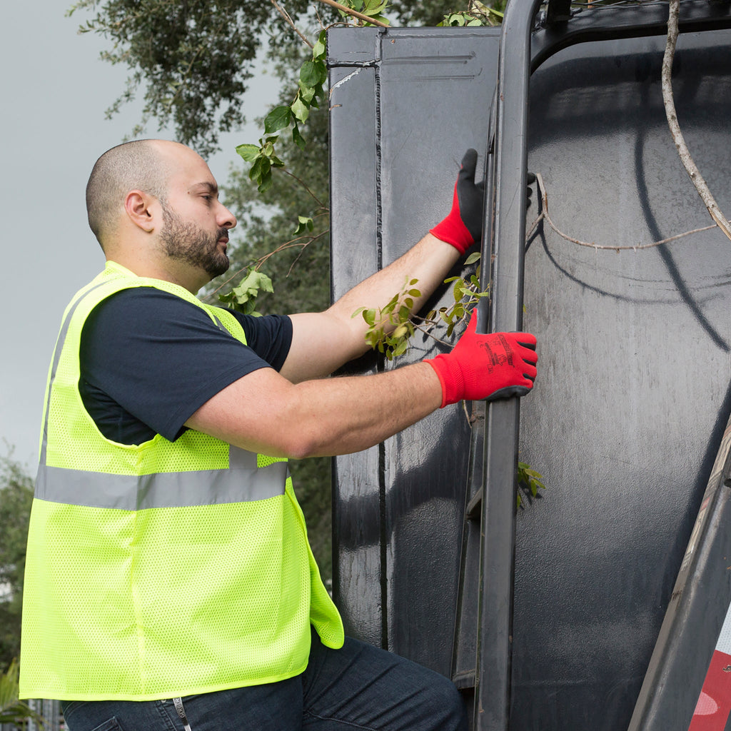 Worker wearing the JORESTECH lime safety vest while he is next to a large truck