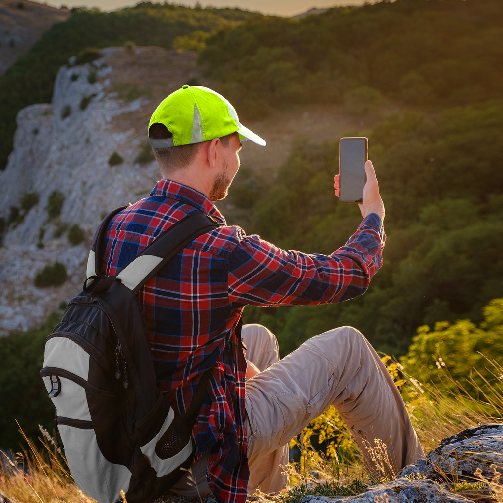 A person highking a mountain wearing the JORESTECH hi visibility safety cap with reflective stripes for su protection and increase visibility