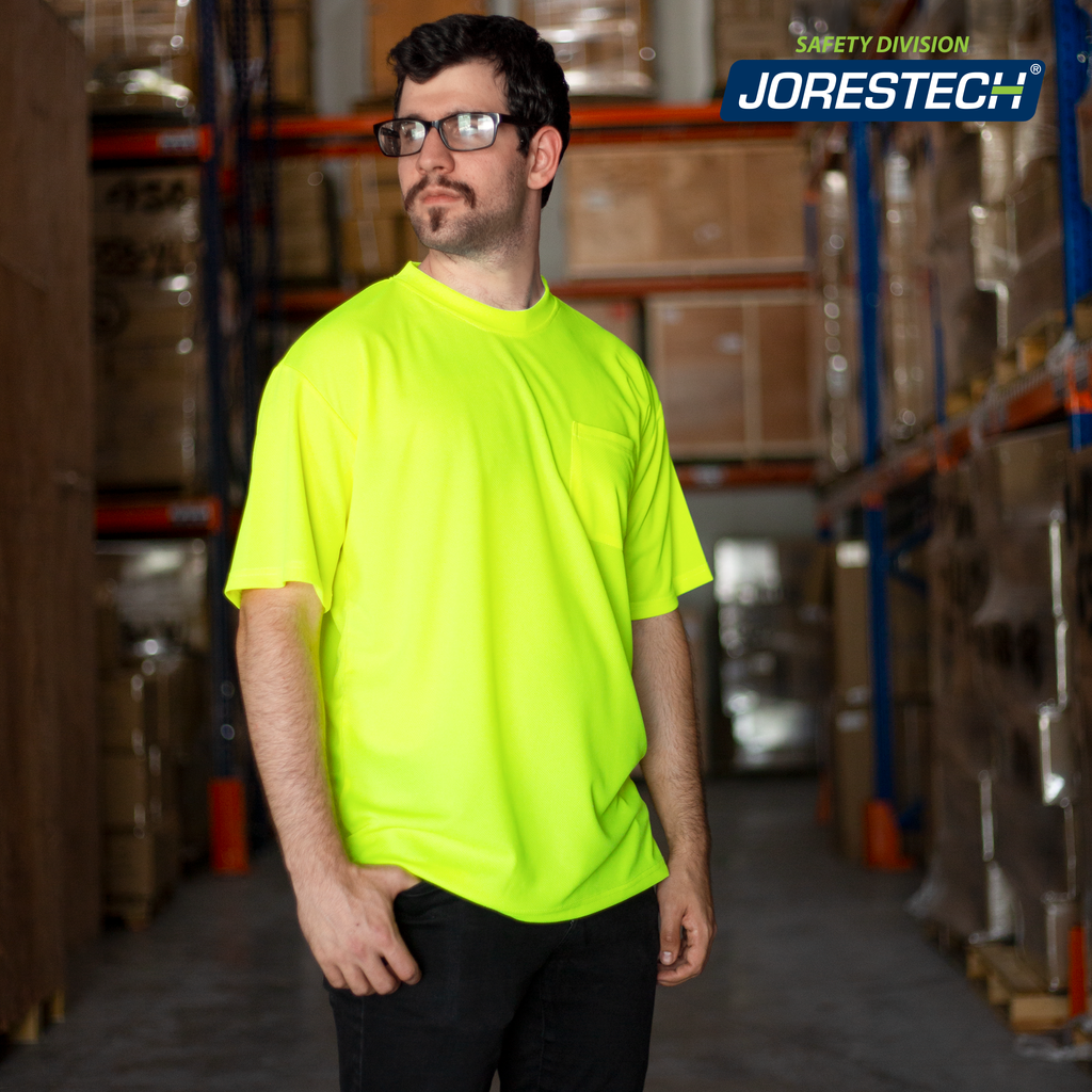 Image of a smiling man wearing the JORESTECH hi-vis Yellow/Lime safety shirt  inside a warehouse filled with brown boxes