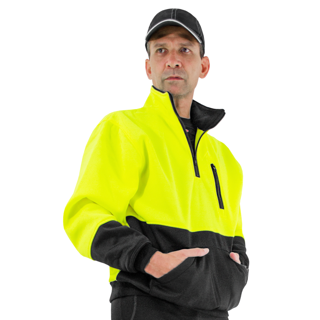 Image of a man wearing the hi-vis Yellow Lime safety sweater and a sports cap. His hands are inside the front pocket, and the half zipper is open. Image over white background.